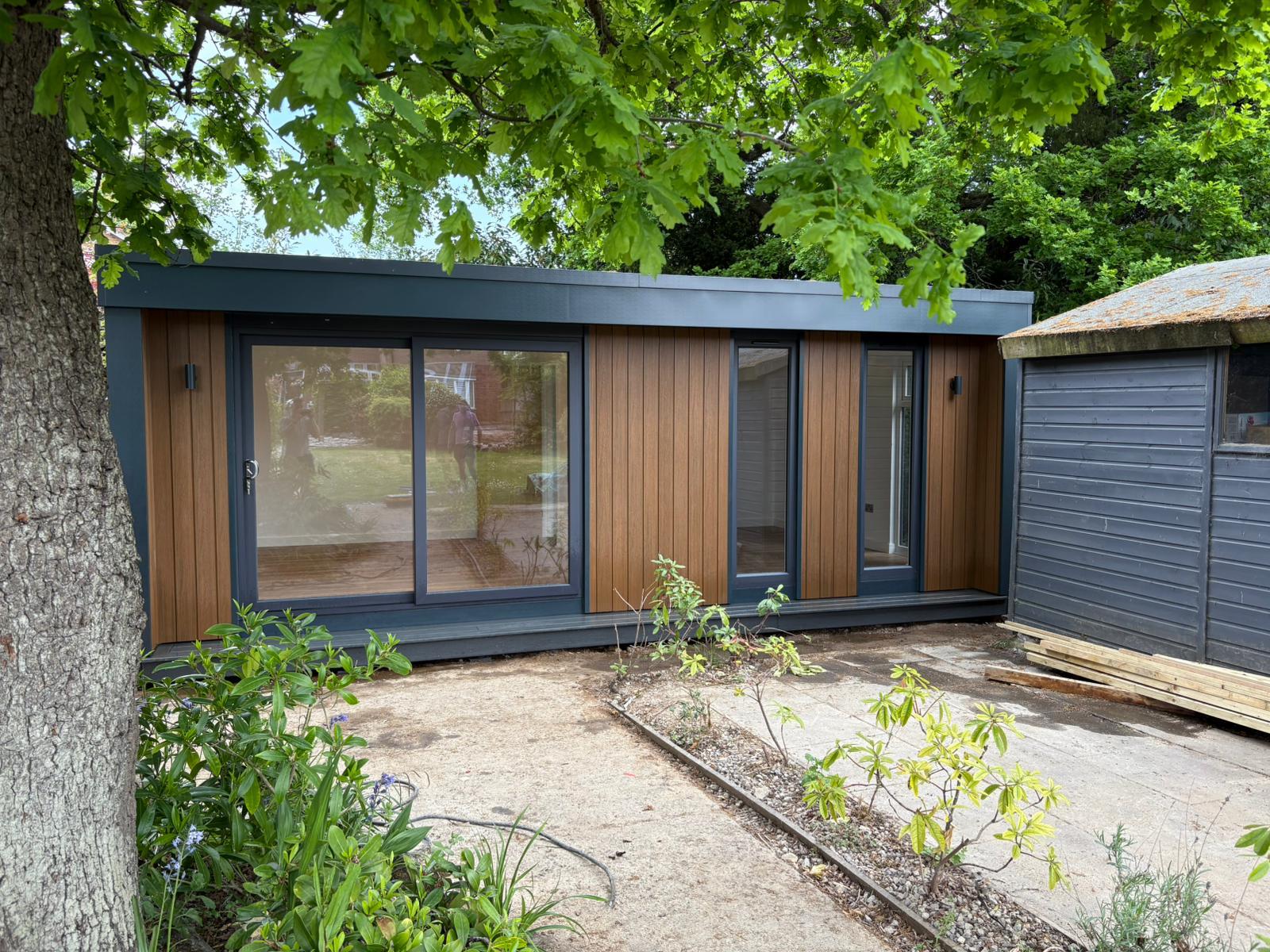 Garden room in leafy setting with light wood finish composite cladding