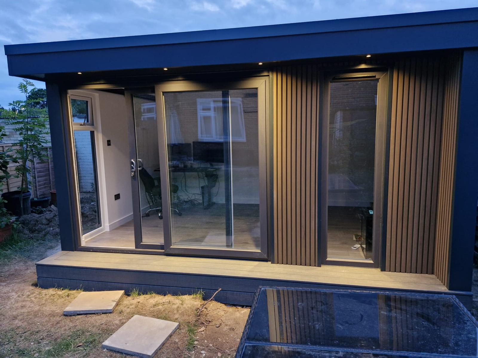 Garden room at dusk with integrated lighting and vertical composite cladding